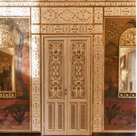 Sala degli Specchi, parete con porta e  due specchiere ai lati decorate