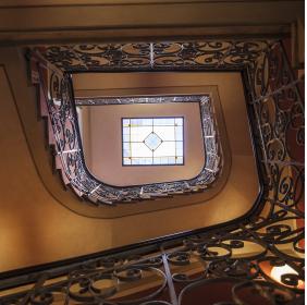 The main staircase with a silver tread iron railing, viewed from below 