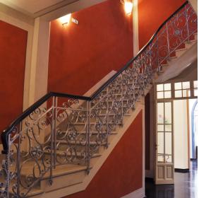 The main staircase with a silver tread iron railing, viewed from the room